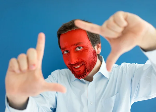 Retrato de jovem com rosto pintado de vermelho — Fotografia de Stock