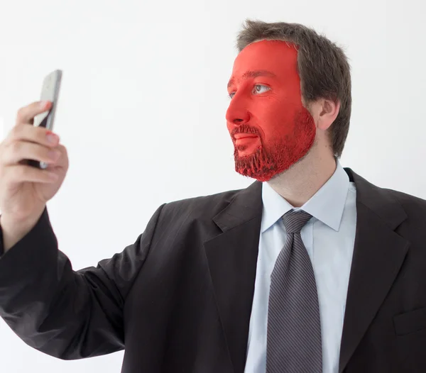 Retrato jovem com rosto pintado de vermelho e smartphone — Fotografia de Stock