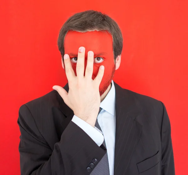 Jonge man portret met rode geschilderde gezicht — Stockfoto