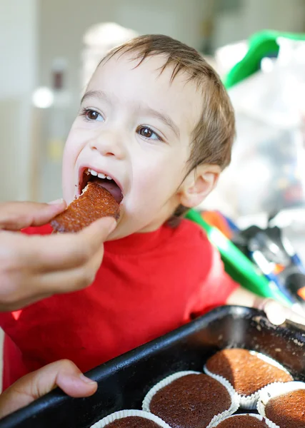 Cute little child eating homemade cupcakes — Stock Photo, Image