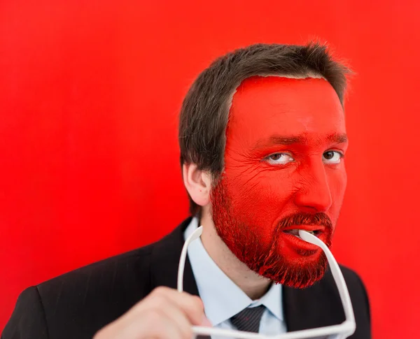 Ung man porträtt med röda målade ansikte — Stockfoto
