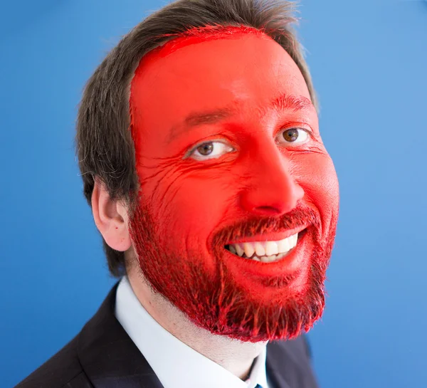 Genç portait kırmızı boyalı yüzü olan adam — Stok fotoğraf