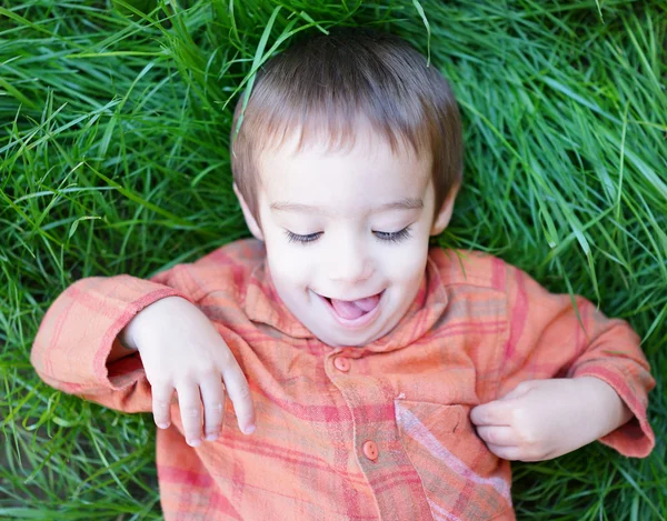 Chłopiec dziecko, leżąc na trawie — Zdjęcie stockowe