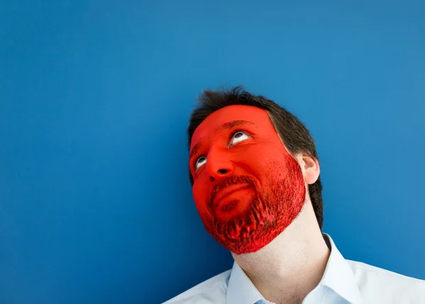 Young man portait with red painted face Royalty Free Stock Photos