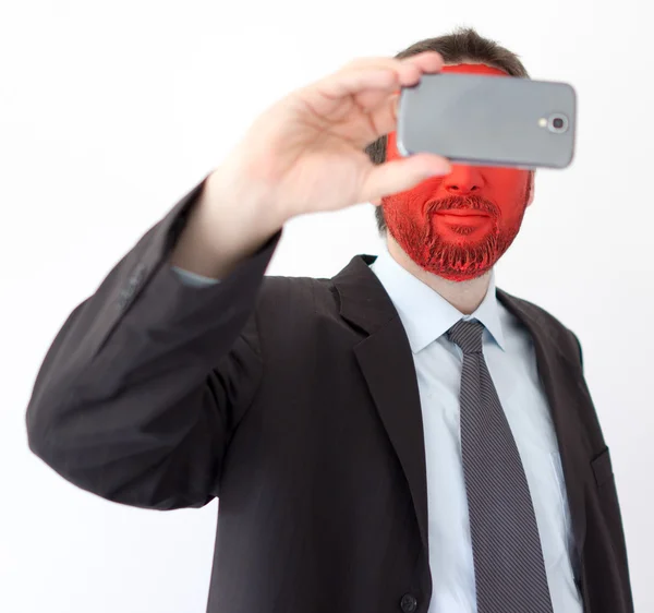 Młody mężczyzna portret z czerwoną twarzą malowane i smartphone Obrazy Stockowe bez tantiem