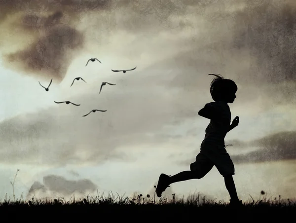 Silueta de niño corriendo en el prado — Foto de Stock
