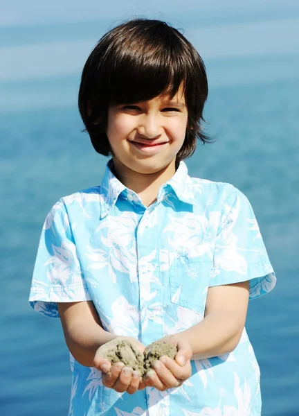 Bambino sulla spiaggia che gioca con la sabbia — Foto Stock