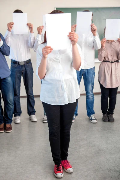 Studenten halten leere Zettel vor die Köpfe — Stockfoto