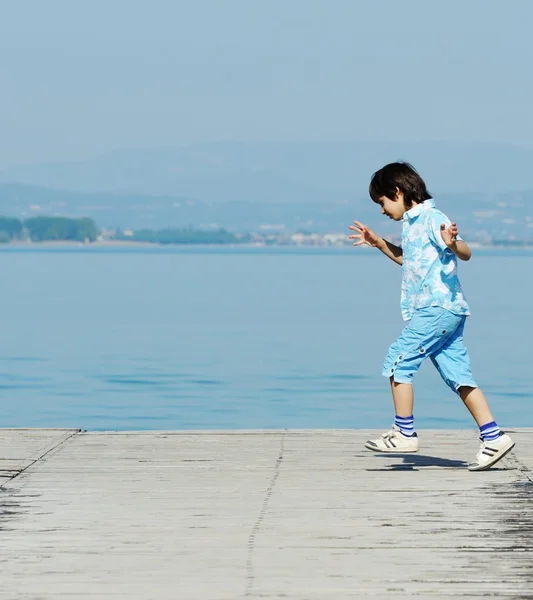 Pojke på en vacker sjö docka — Stockfoto