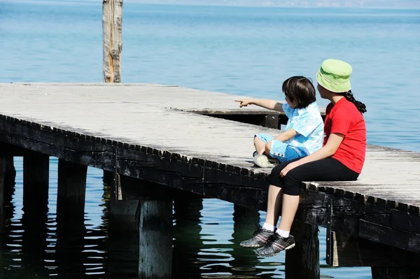 Niño y niña en el muelle de madera —  Fotos de Stock