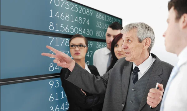 Grupo exitoso analizando el mercado de valores en la gran pantalla digital — Foto de Stock