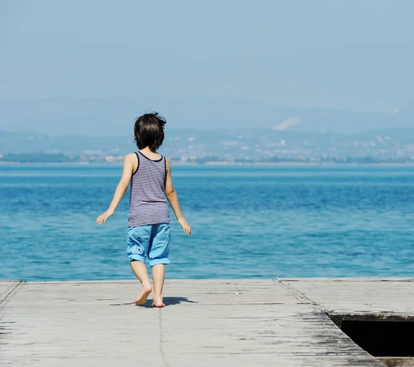 Ragazzino che cammina sul molo — Foto Stock