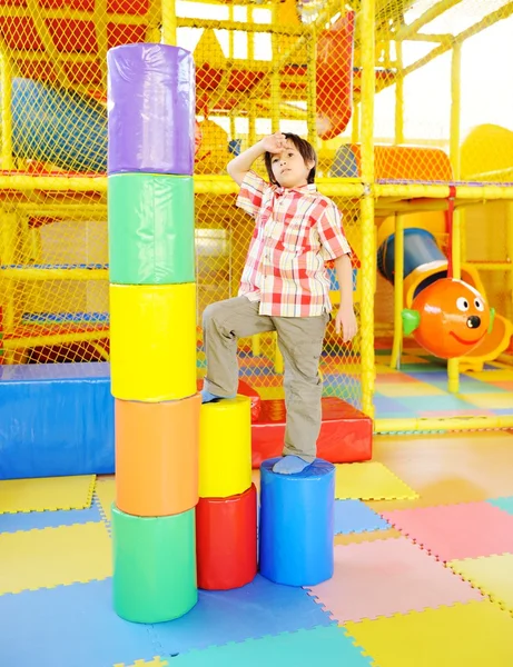 Enfant jouant sur l'aire de jeux de jardin d'enfants coloré — Photo