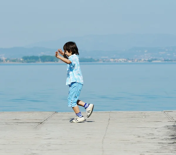 Garçon sur un beau quai du lac — Photo