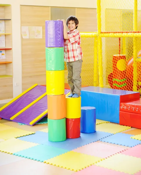 Kind spielt auf buntem Kindergartenspielplatz — Stockfoto