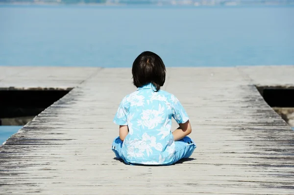 在一个美丽的湖码头上的男孩 — 图库照片