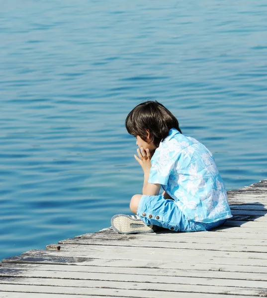 Criança por doca de madeira em um belo mar — Fotografia de Stock