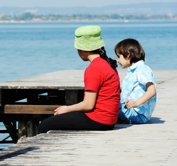 Menino e menina na doca de madeira — Fotografia de Stock