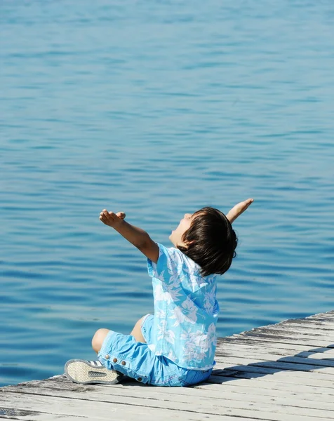 Dítě tím dřevěná dok na krásné moře — Stock fotografie