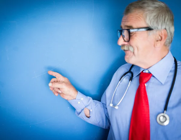 一位资深的医生在蓝色的医学背景的肖像 — 图库照片