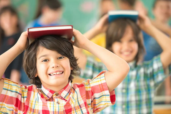 Children with books on heads — Stock Photo, Image