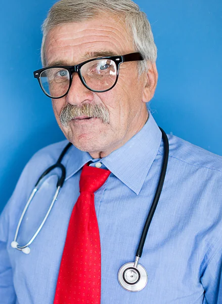 Portrait of a senior doctor on blue medical background