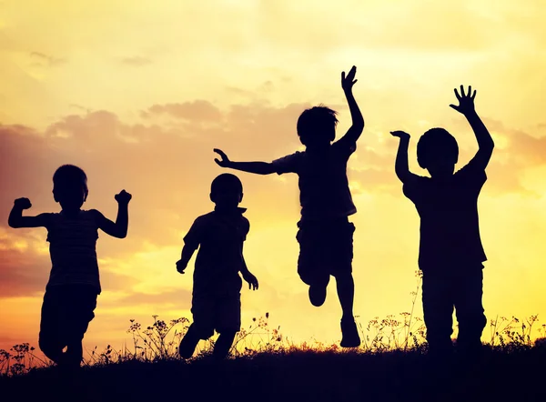 Grupo de crianças felizes brincando no prado — Fotografia de Stock