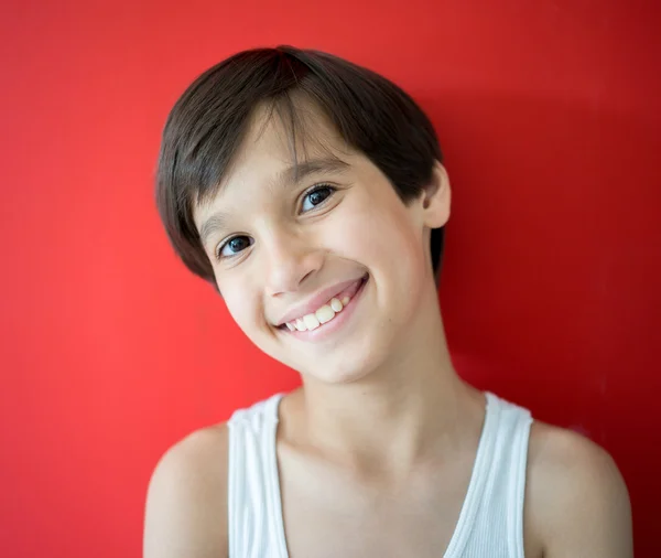 Entzückender kleiner Junge auf rotem Hintergrund — Stockfoto