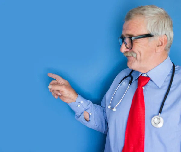 Ritratto di un medico anziano su sfondo medico blu — Foto Stock