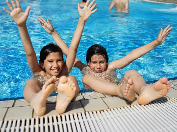 Crianças felizes desfrutando na piscina de verão — Fotografia de Stock