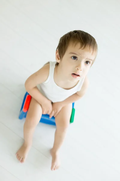 Entzückender kleiner Junge auf der Toilette Stockfoto