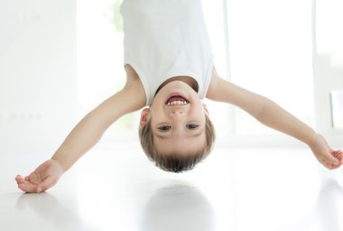 Aşağı ters mutlu bir küçük çocuk