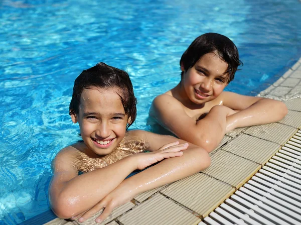 Niños felices disfrutando en la piscina de verano —  Fotos de Stock