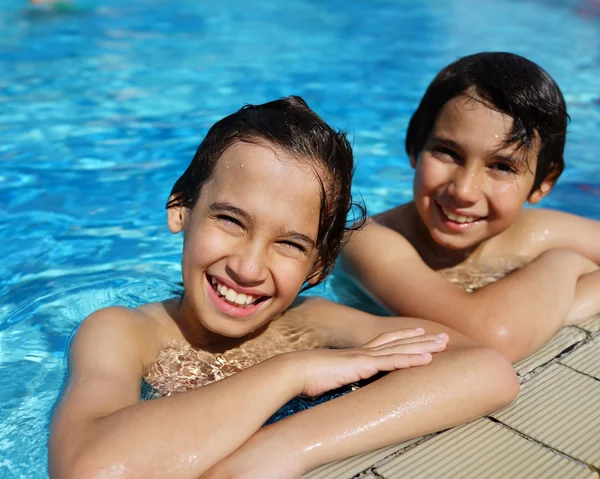 Gelukkige jonge geitjes in de zomerzwembad genieten — Stockfoto