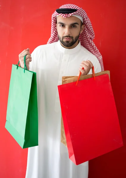 Homem árabe segurando sacos de compras — Fotografia de Stock