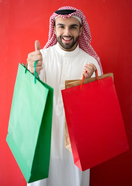 Homem árabe segurando sacos de compras — Fotografia de Stock