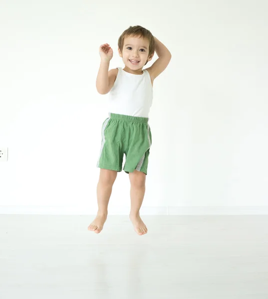 Bedårande liten pojke hemma jumping — Stockfoto