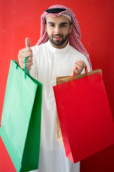 Homem árabe segurando sacos de compras — Fotografia de Stock