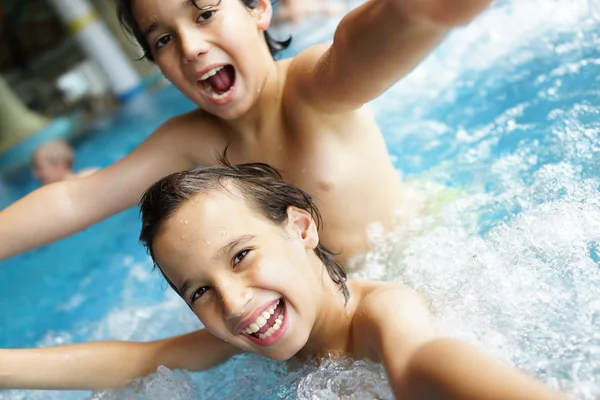 Glada barn njuta av simning — Stockfoto