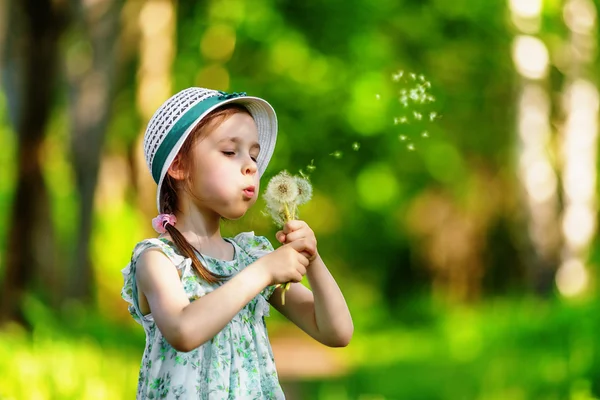 Μικρό κορίτσι φυσώντας πικραλίδα — Φωτογραφία Αρχείου
