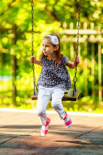 Pretty little girl swinging on seesaw — Stock Photo, Image