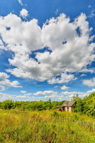 Abandoned hut beneath cloudy sky — Stock Photo, Image