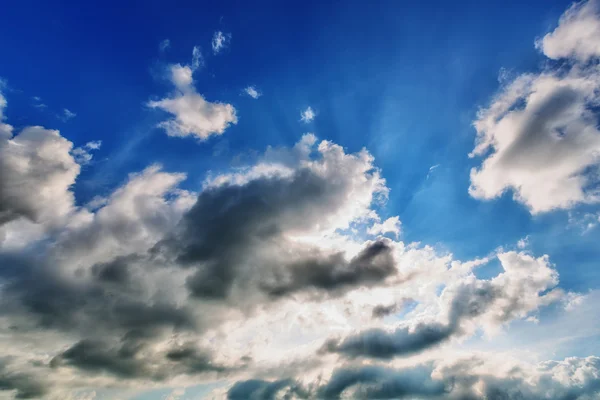 Blue cloudy sky with sun rays — Stock Photo, Image