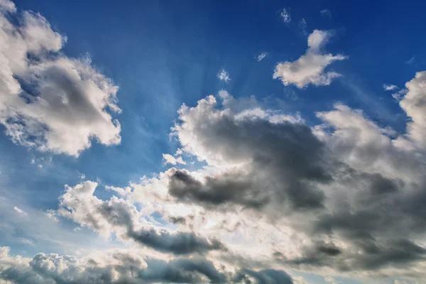 Blue cloudy sky with sun rays — Stock Photo, Image