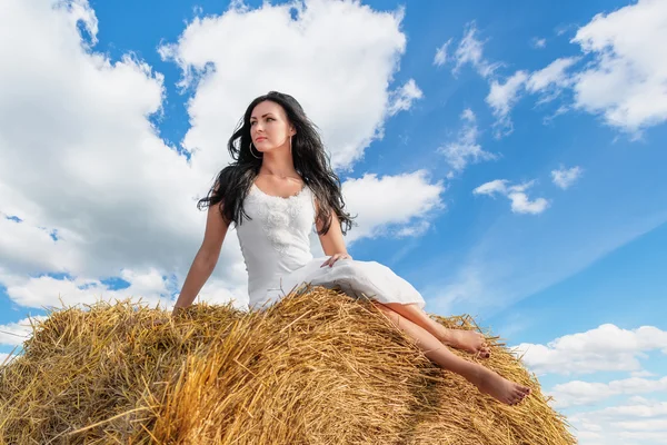 Brunette woman on hay bale — Stock Photo, Image