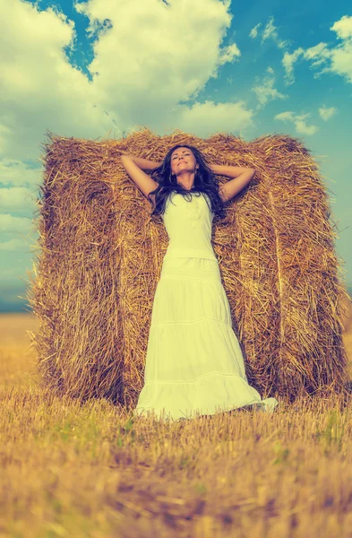 Brunette woman near hay bale — Stock Photo, Image