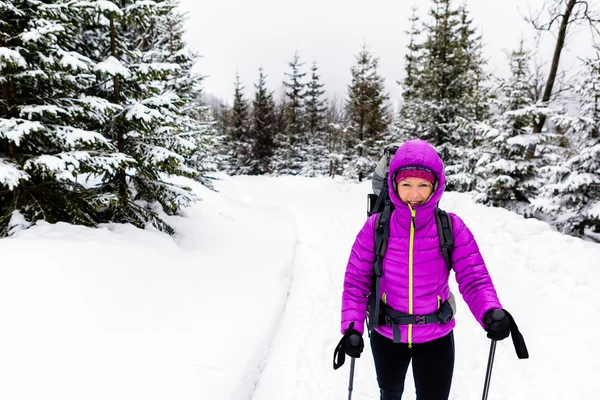 Lycklig kvinna gå i vinter skogen med ryggsäck — Stockfoto