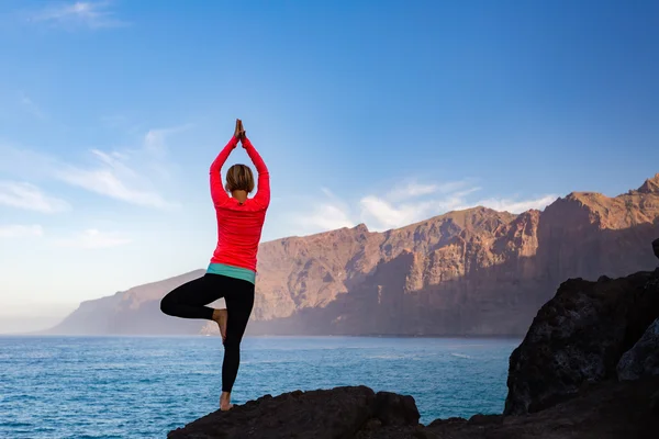 Vrouw mediteren in yoga vrksasana boom pose — Stockfoto