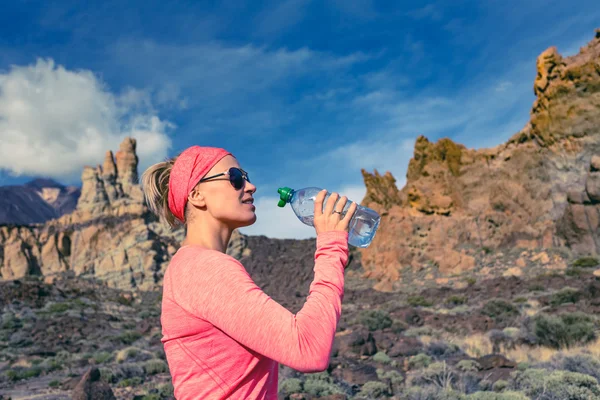 饮酒的女小径跑步运动员鼓舞人心的山 — 图库照片
