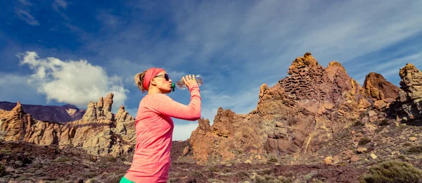 Vrouw trail runner drinken in inspirerende Bergen landschap — Stockfoto